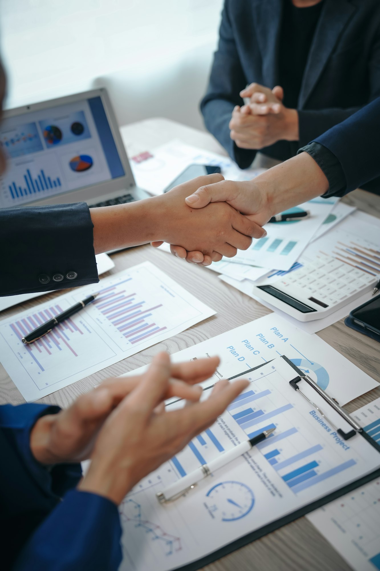 business team meeting, success is celebrated with handshake. Hands close up, dressed in formal suit